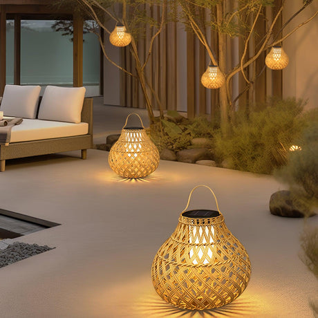Lanterns hanging lit from a bare tree over a courtyard with a sofa