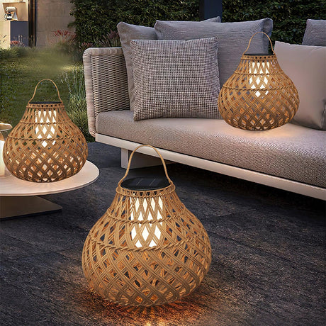 The lantern lit on a low table beside a garden sofa with cushions