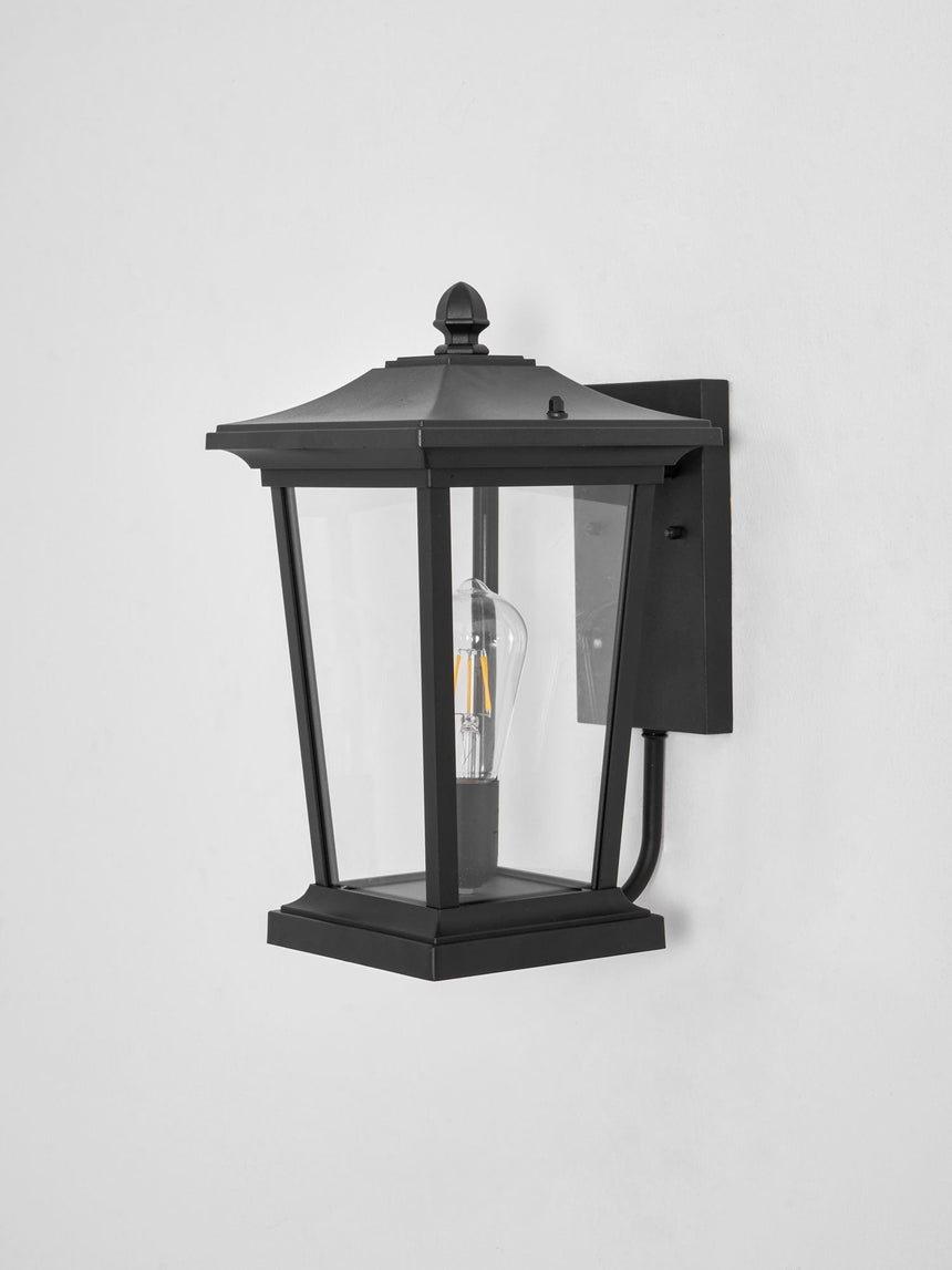 The black lantern with clear glass, the bulb visible inside