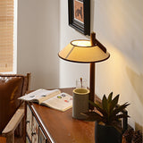 Cement base lamp lit in a corner beside a leather armchair