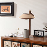 Cement base lamp lit on a cabinet beside a flip calendar and a cup
