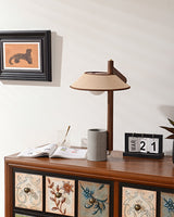 Cement base lamp lit on a cabinet below a small framed print