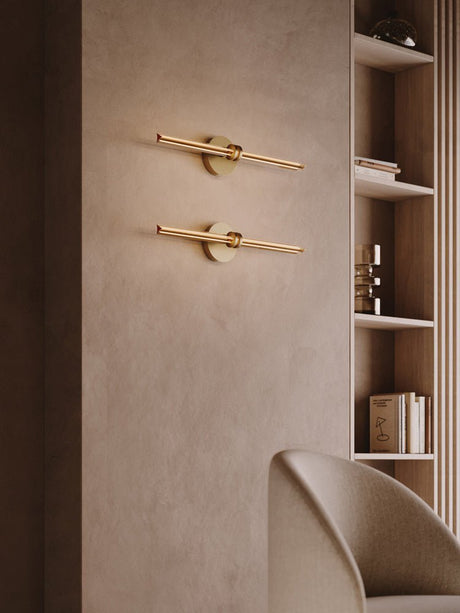 Two rods lit one above the other on a plaster wall beside shelving and a chair