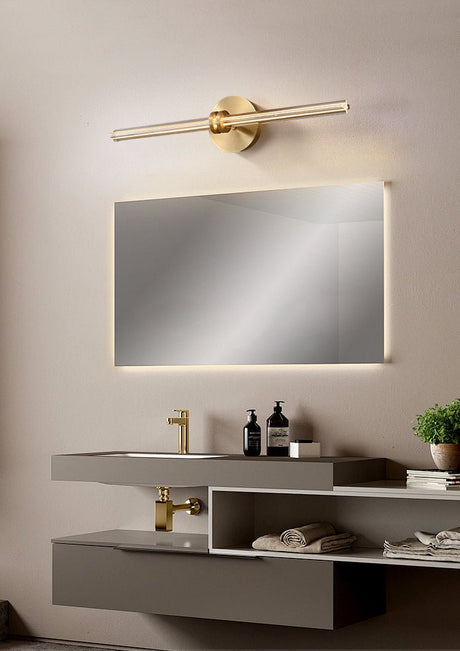 Rod lit above a mirror on a stone vanity with a folded towel and a plant