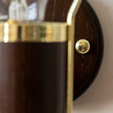 Close view of the wood backplate and the single screw that holds the arm