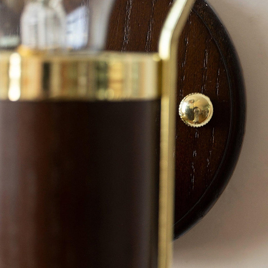 Close view of the wood backplate and the single screw that holds the arm