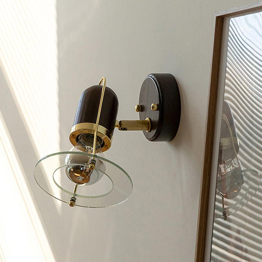 Sconce unlit beside a tall wood mirror frame and a blind in a pale room