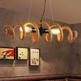Coiled rope fitting lit on a plaster wall beside two framed prints