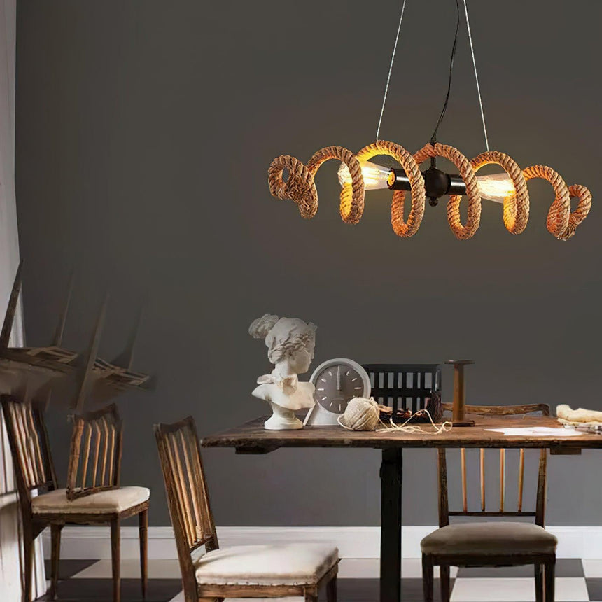 The coil lit above a dining table with cane chairs around it