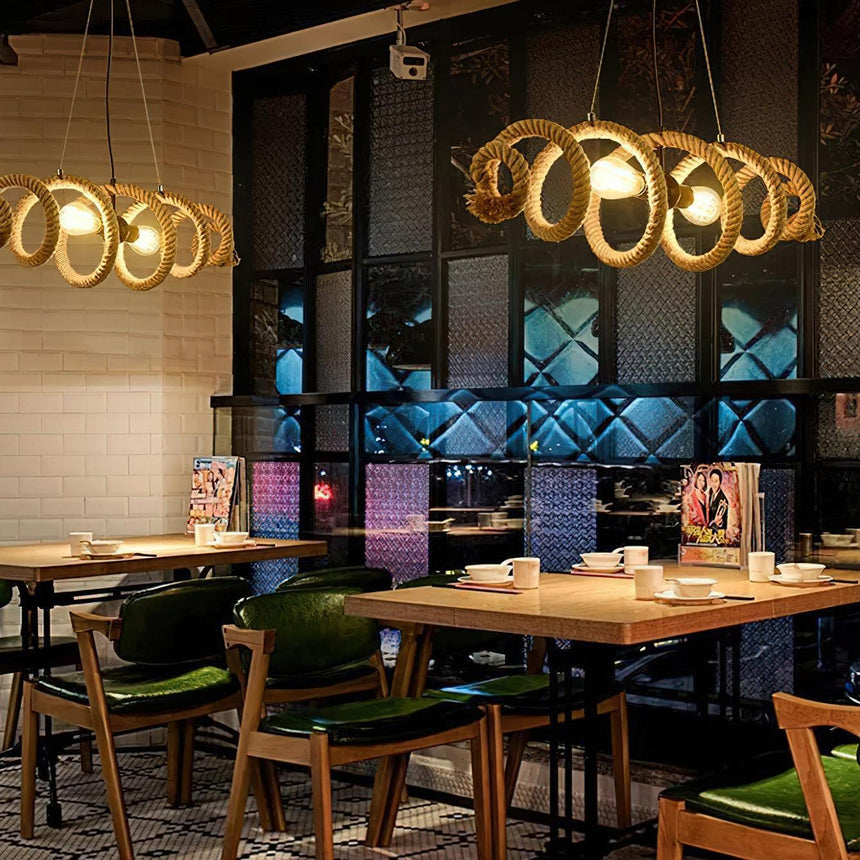Two of the fittings lit above tables in a wood lined dining room