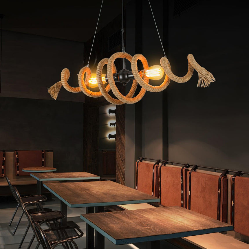Chandelier lit above a long table with leather booth seating beyond