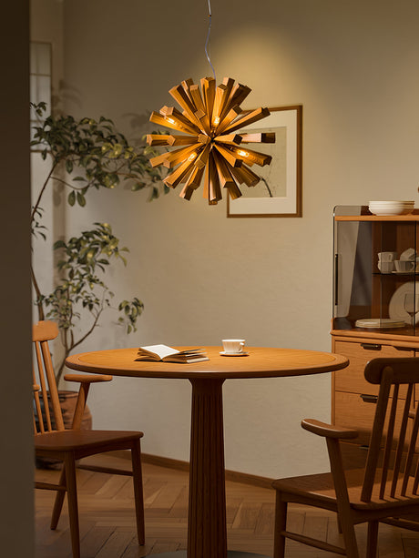 Chandelier lit above a round wood table set with two cups