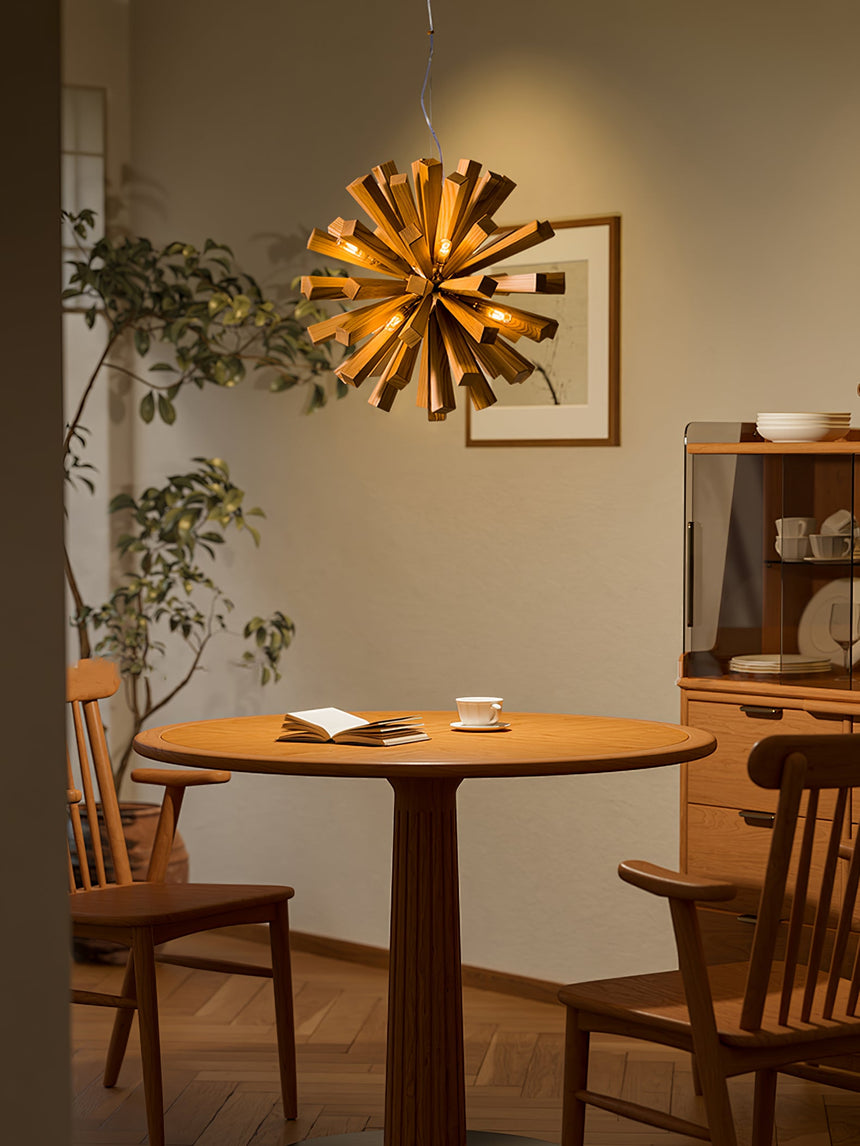 Chandelier lit above a round wood table set with two cups