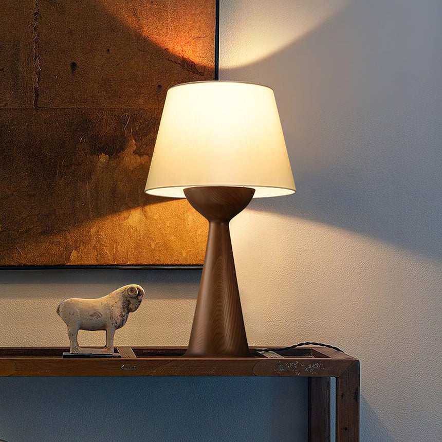 Japandi table lamp lit on a console in front of a rusted metal panel