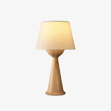 Japandi table lamp with a cloth shade on a wood hourglass base, plain background
