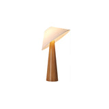 Natural wood table lamp lit, the tilted shade catching the light