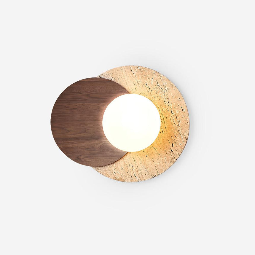 Japandi wall sconce with a glass orb between a walnut and a stone disc