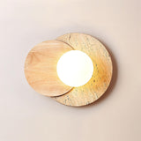 Light wood disc over travertine, the white glass orb glowing warm