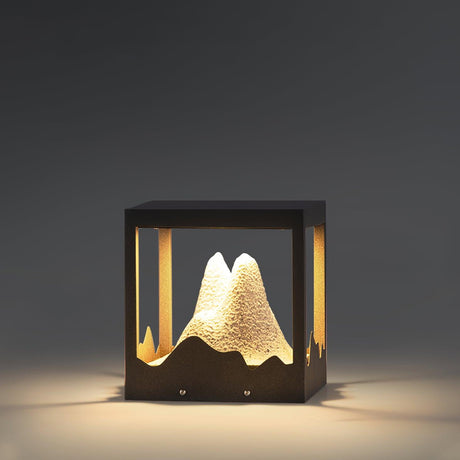 The resin peak lit warm inside its frame against a dark garden