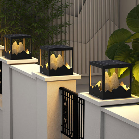 The frame lit on a white pillar beside a dark slatted garden fence