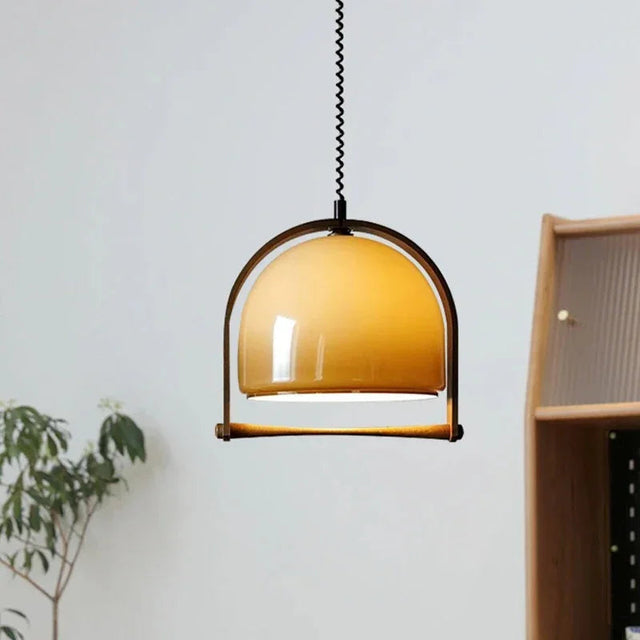 The amber glass dome in a wooden arch lit beside a shelf and a plant