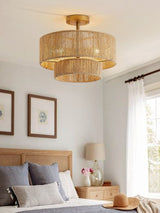 Jute ceiling light lit in a bedroom with a wood headboard and framed prints