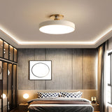 White drum ceiling light above a bed in a room with wood paneling