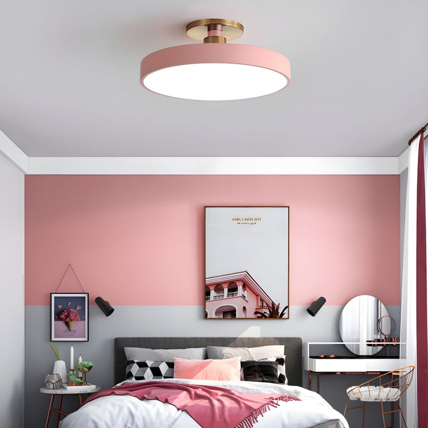 Pink drum ceiling light in a bedroom with pink walls and a desk