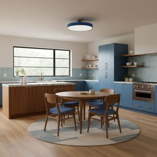 Blue drum ceiling light above a round dining table in a blue kitchen