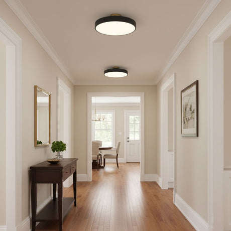 Black drum ceiling lights along a hallway with a console table