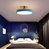 Blue drum ceiling light above a bed in a room with navy walls