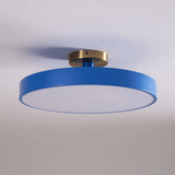 Blue drum ceiling light lit against a pale backdrop