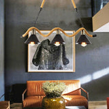 Chandelier lit above a leather sofa with framed artwork behind it