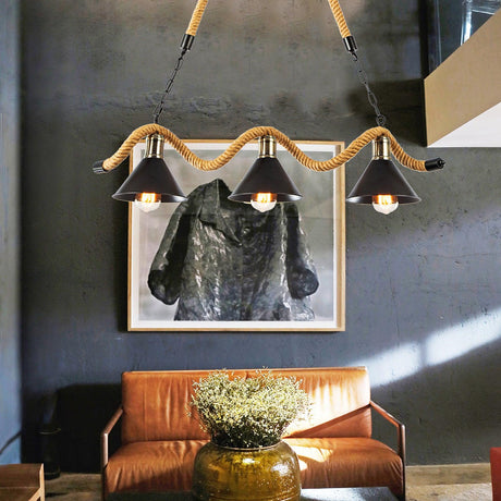 Chandelier lit above a leather sofa with framed artwork behind it