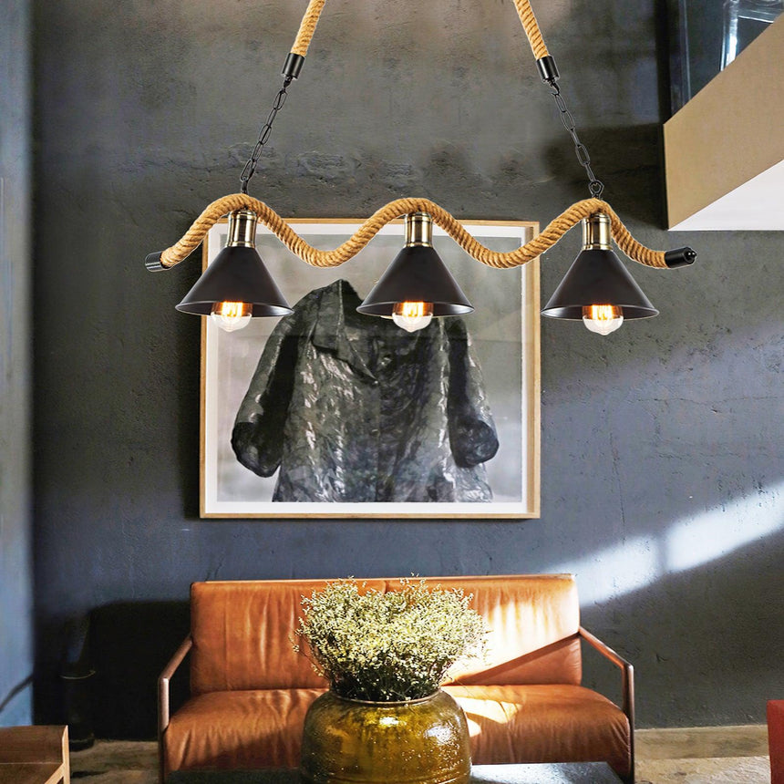 Chandelier lit above a leather sofa with framed artwork behind it