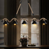Chandelier lit by a window above a console with a bowl on it