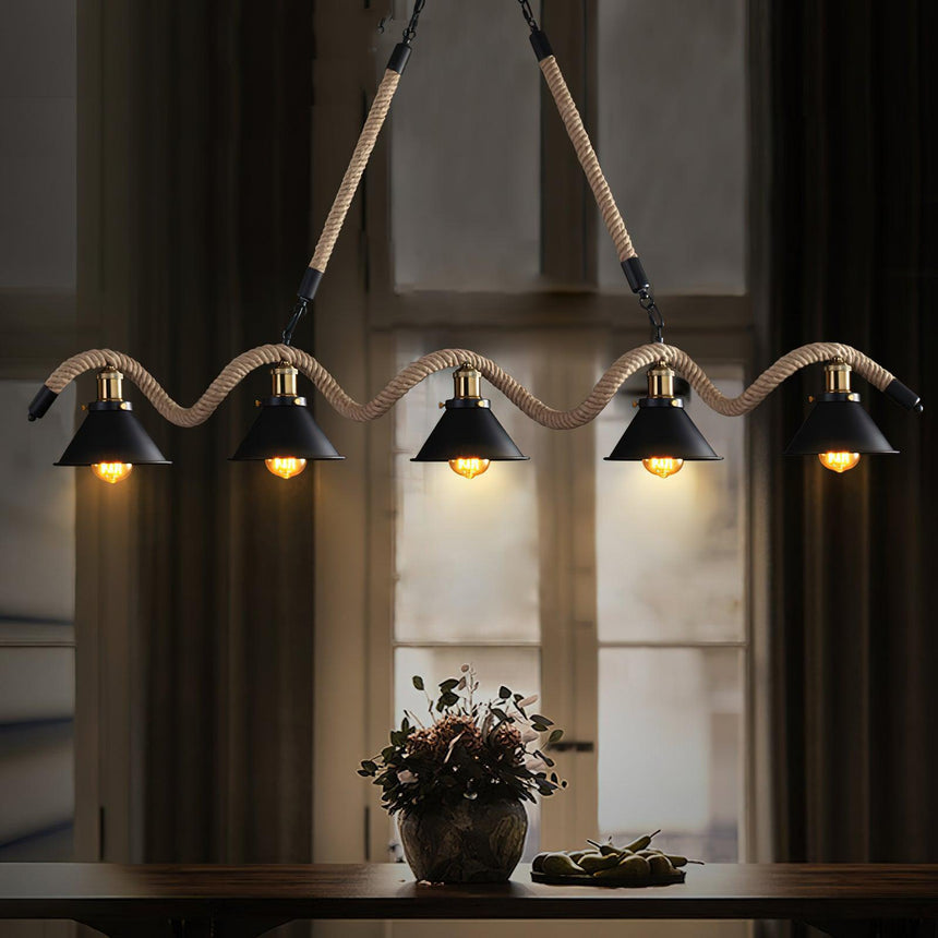 Chandelier lit by a window above a console with a bowl on it