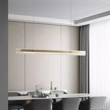 The slim lit bar hung above a kitchen island with chairs around it