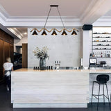The wave lit above a pale counter with a vase and stools beside it