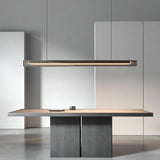 The lit bar hung above a dark table in a pale room with a counter