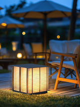 The cube lit on a deck under a garden umbrella beside a lounge chair
