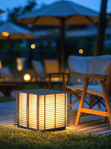 The cube lit on a deck under a garden umbrella beside a lounge chair