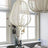 Lantern ceiling light in ivory fabric over a wire frame beside a window