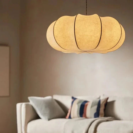 Ribbed silk lantern lit warm above a sofa