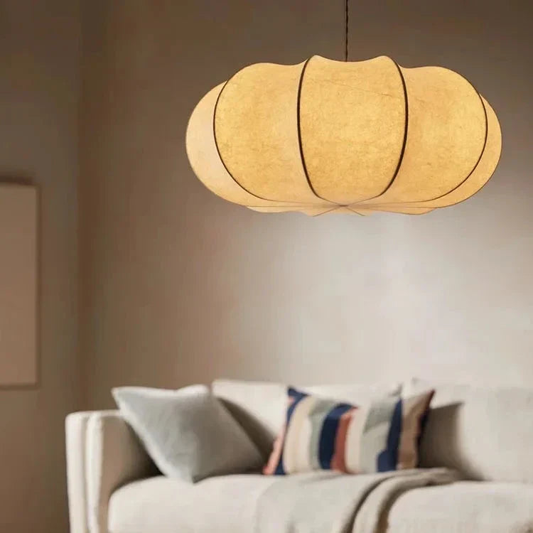 Ribbed silk lantern lit warm above a sofa