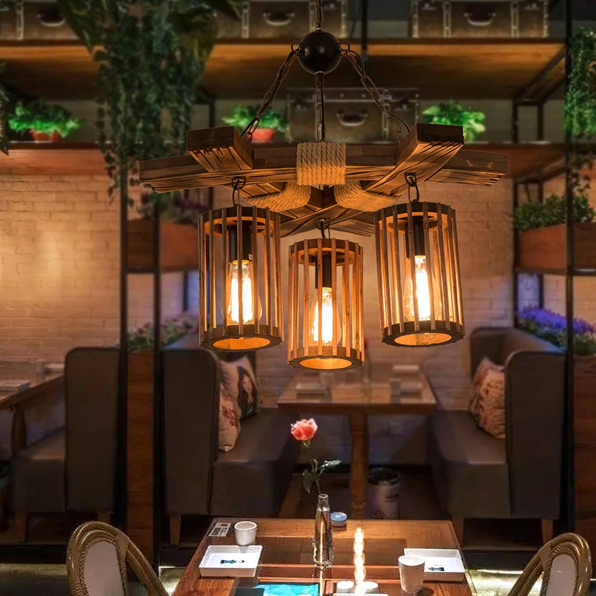 Chandelier lit above a table in a room with a planted wall behind