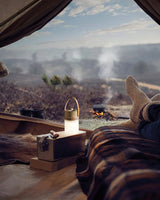 Lantern table lamp lit inside a tent looking out over a landscape