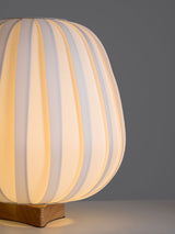 Close view of the small wood cross foot under the pleated shade