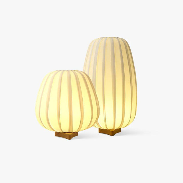 Two pleated fabric lantern lamps side by side on small wood feet