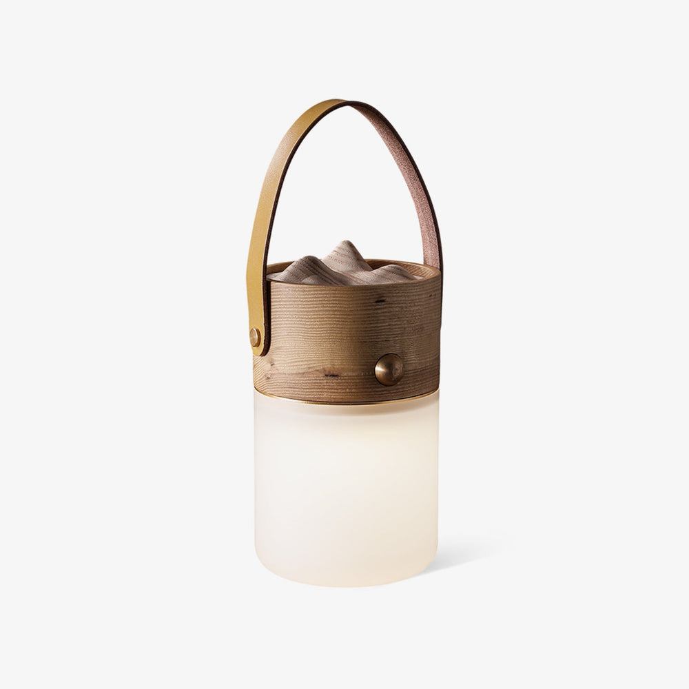 Lantern table lamp with a leather strap and a carved wood top, plain background